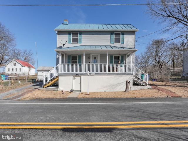 view of front of property featuring covered porch, metal roof, a standing seam roof, and stairs