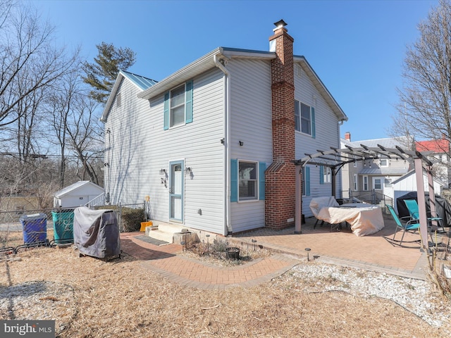 back of house with a chimney, fence, a pergola, and a patio