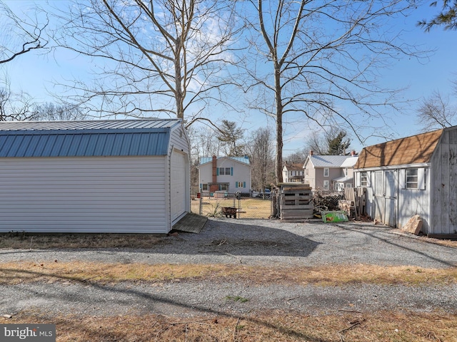 view of yard with an outbuilding, fence, and a residential view