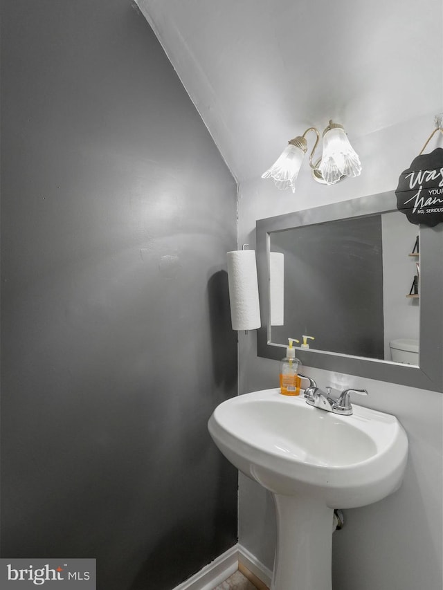 bathroom featuring a sink, toilet, and baseboards