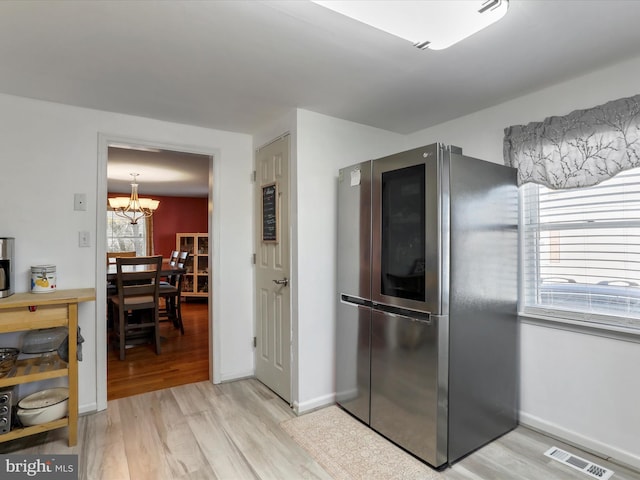 kitchen with a chandelier, light wood finished floors, smart refrigerator, and visible vents