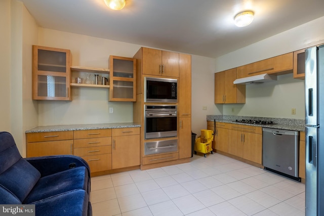 kitchen featuring light stone counters and black appliances