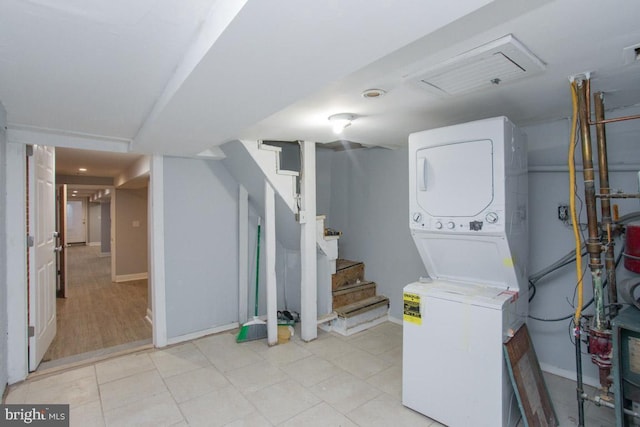 clothes washing area with stacked washer / dryer