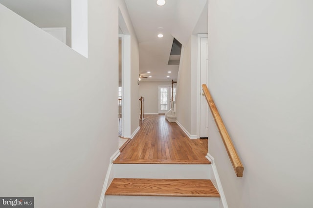 stairway featuring recessed lighting, wood finished floors, and baseboards