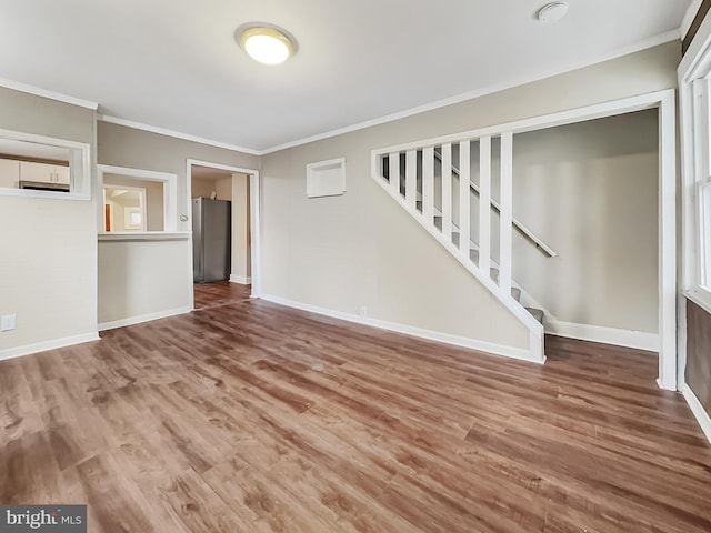 unfurnished living room featuring hardwood / wood-style flooring and ornamental molding