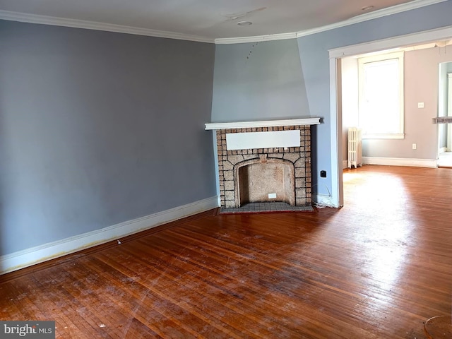 unfurnished living room with crown molding, a fireplace, radiator, and hardwood / wood-style flooring