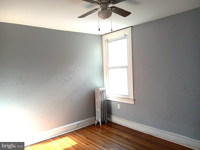 unfurnished room with ceiling fan, radiator heating unit, and wood-type flooring