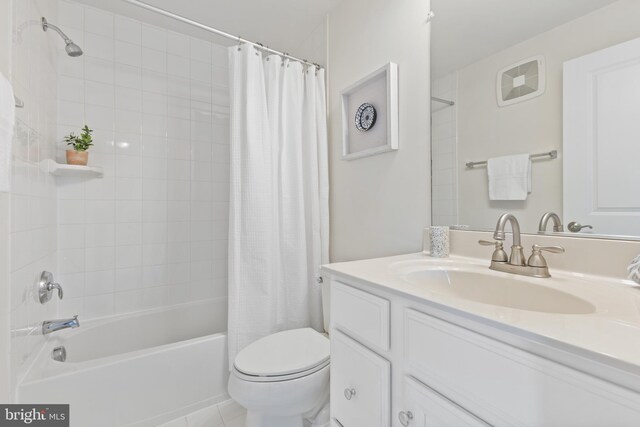 full bath with toilet, tile patterned floors, shower / bath combination with curtain, and vanity