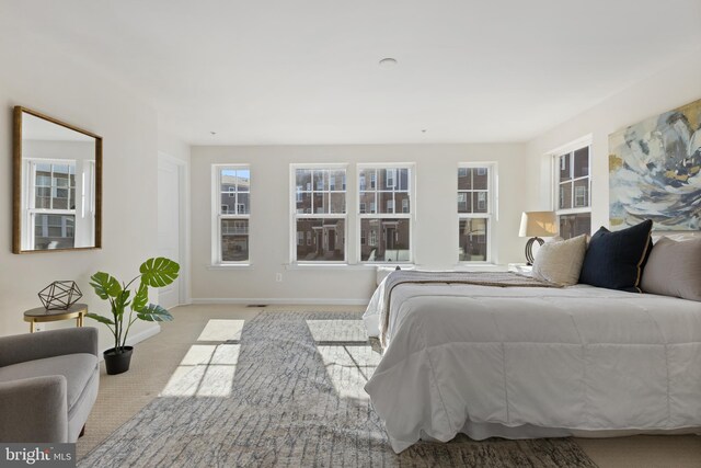 bedroom with light colored carpet and baseboards