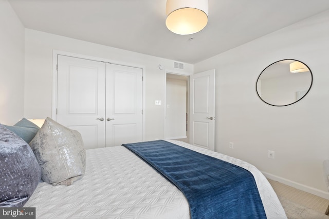 bedroom with a closet, visible vents, and baseboards