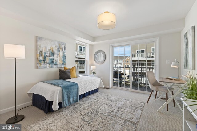 carpeted bedroom with baseboards and access to exterior