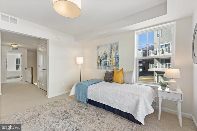bedroom with light carpet, visible vents, and baseboards