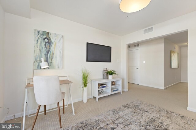 office space featuring light colored carpet, visible vents, and baseboards