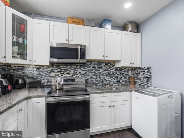 kitchen featuring a sink, decorative backsplash, white cabinetry, and stainless steel appliances