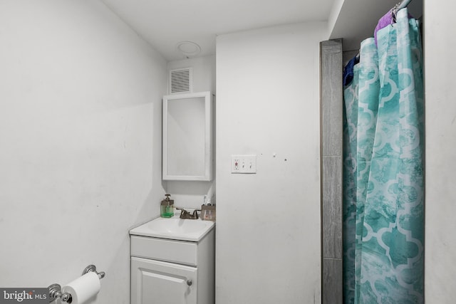 bathroom featuring vanity, a shower with shower curtain, and visible vents