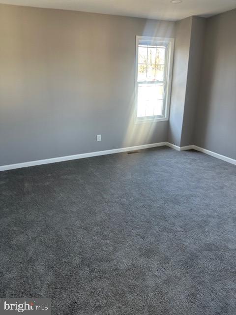 empty room featuring dark carpet