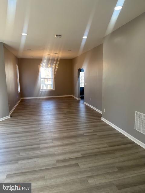 unfurnished room featuring hardwood / wood-style flooring and a chandelier