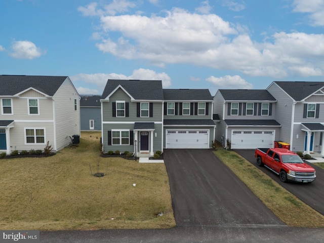 multi unit property with a garage and a front yard