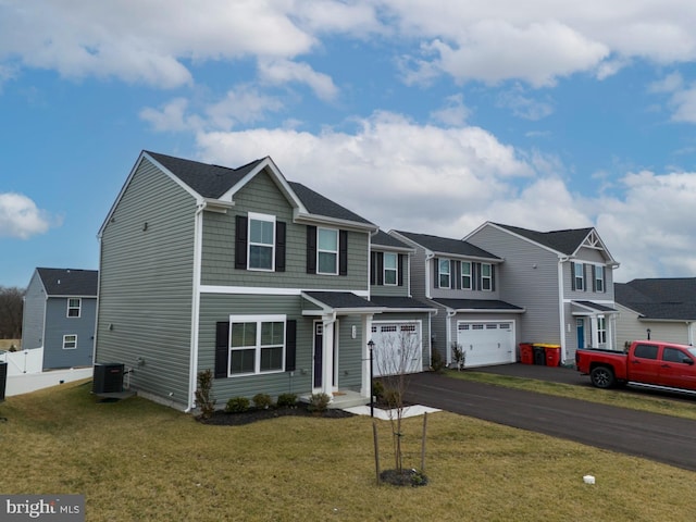 view of front of home featuring a garage, central AC, and a front lawn