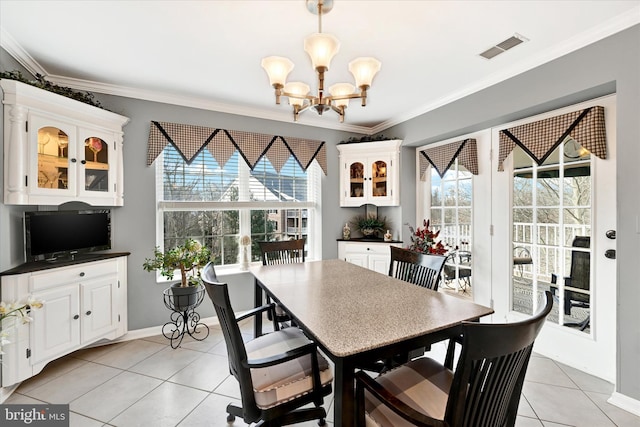 dining room featuring a notable chandelier, light tile patterned floors, and ornamental molding