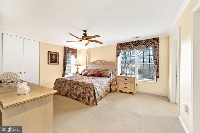 bedroom featuring crown molding, light colored carpet, and ceiling fan