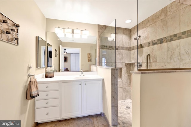 bathroom with tiled shower and vanity