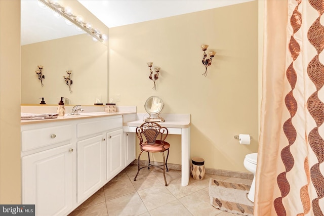 bathroom with tile patterned flooring, vanity, and toilet