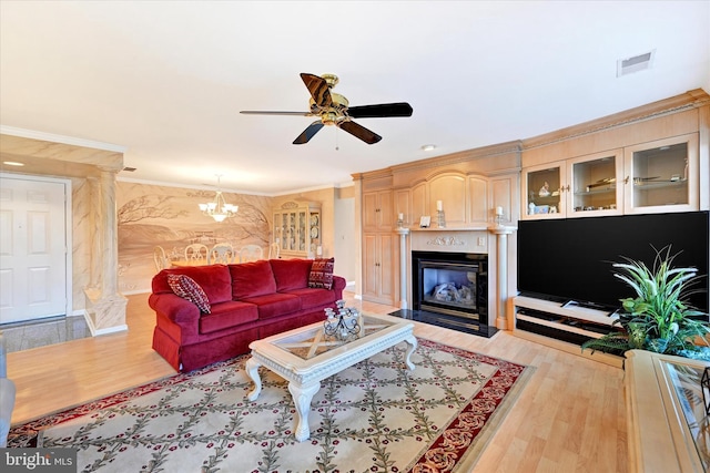 living room with crown molding, ceiling fan with notable chandelier, and light hardwood / wood-style flooring