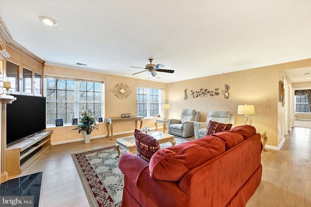 living room featuring ornamental molding, plenty of natural light, and light hardwood / wood-style floors