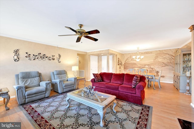 living room with ornamental molding, wood-type flooring, and ceiling fan with notable chandelier