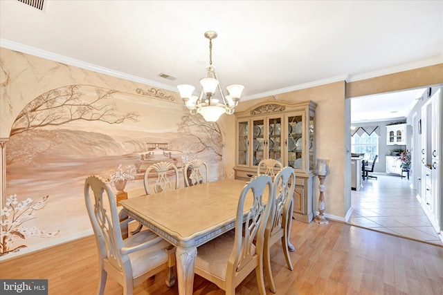 dining room featuring hardwood / wood-style flooring, ornamental molding, and a notable chandelier