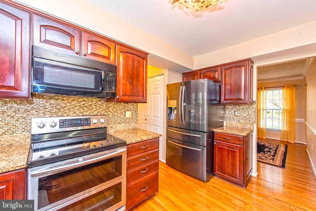 kitchen with stainless steel appliances, light wood finished floors, and light stone countertops