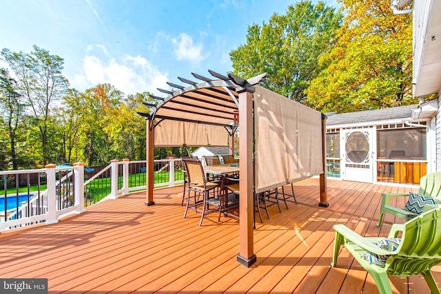 wooden deck with a fenced in pool, a pergola, and outdoor dining space