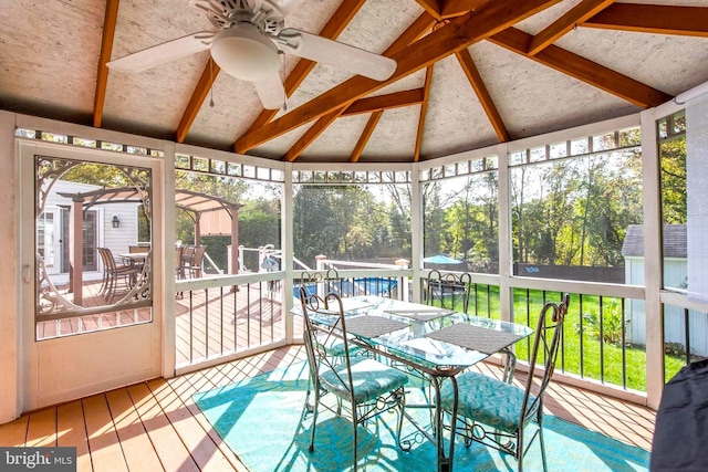 sunroom with vaulted ceiling and a ceiling fan