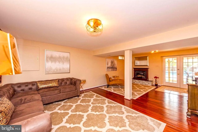 living room with baseboards, wood finished floors, and a glass covered fireplace