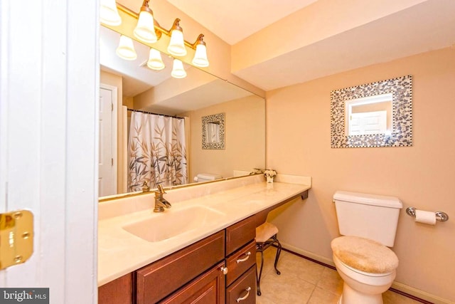 bathroom featuring tile patterned flooring, baseboards, vanity, and toilet