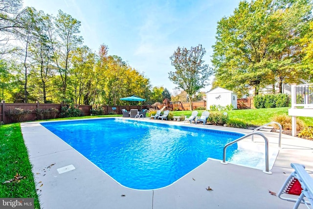 view of swimming pool featuring a fenced in pool, a fenced backyard, a patio, and an outdoor structure