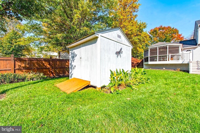 view of shed with a sunroom and fence