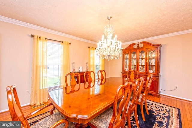 dining area featuring crown molding, wood-type flooring, visible vents, and a notable chandelier