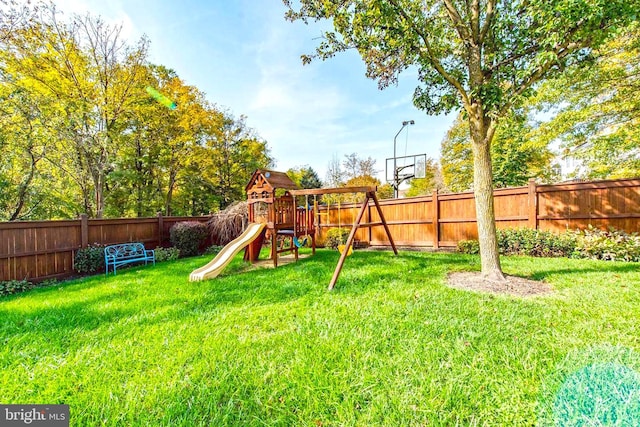 view of playground with a fenced backyard and a lawn