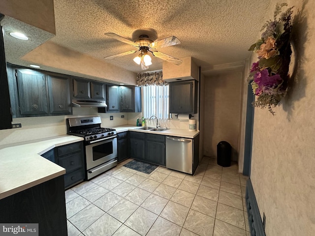 kitchen with sink, a textured ceiling, light tile patterned floors, appliances with stainless steel finishes, and ceiling fan