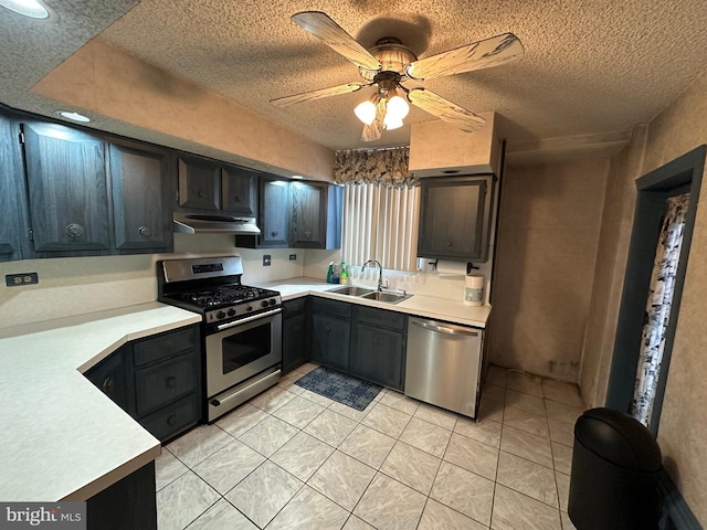 kitchen with sink, a textured ceiling, light tile patterned floors, appliances with stainless steel finishes, and ceiling fan