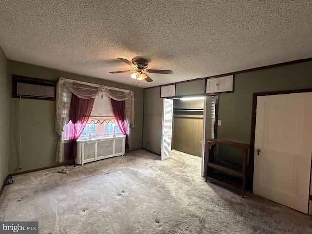 unfurnished bedroom with light colored carpet, radiator heating unit, a wall mounted air conditioner, and a textured ceiling