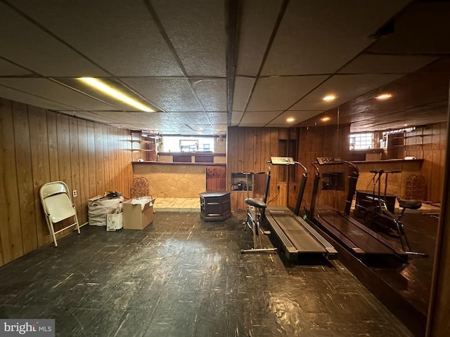 interior space featuring plenty of natural light, a drop ceiling, and wood walls