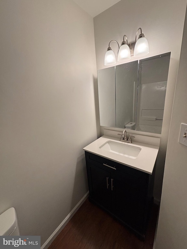 bathroom with vanity, toilet, and wood-type flooring
