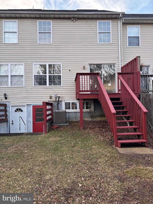 back of house with a lawn and central air condition unit