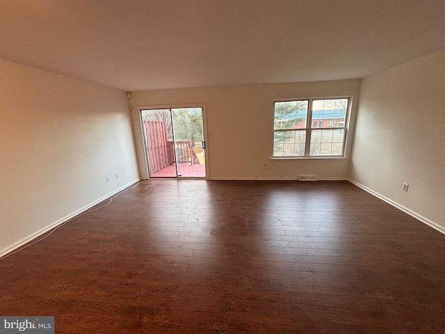 unfurnished room with dark hardwood / wood-style flooring