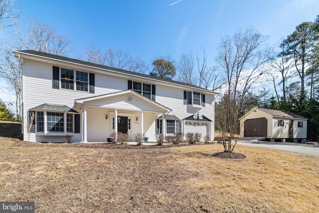 view of front of house with a garage and an outbuilding