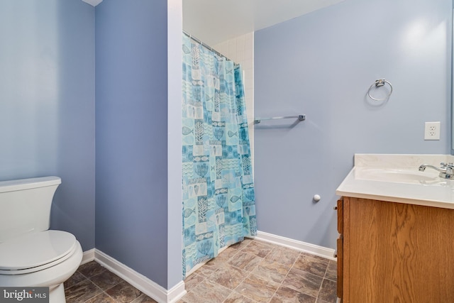 full bath featuring a shower with shower curtain, baseboards, toilet, and vanity