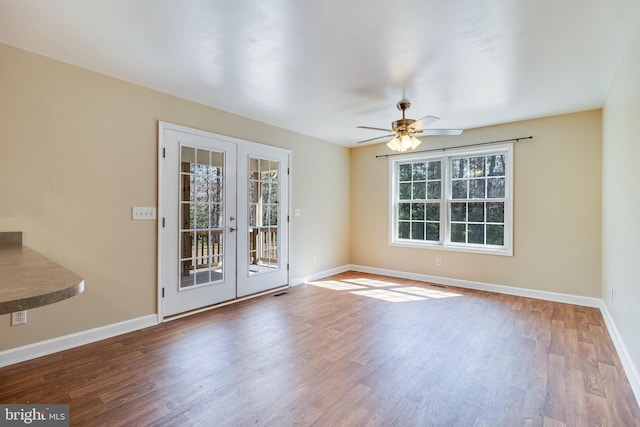 spare room featuring ceiling fan, french doors, baseboards, and wood finished floors